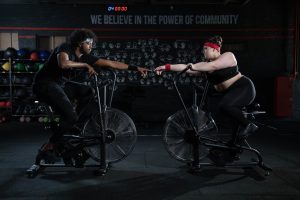 student spinning with personal trainer
