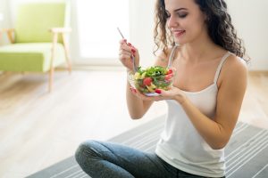 Fitness young woman eating healthy food after workout
